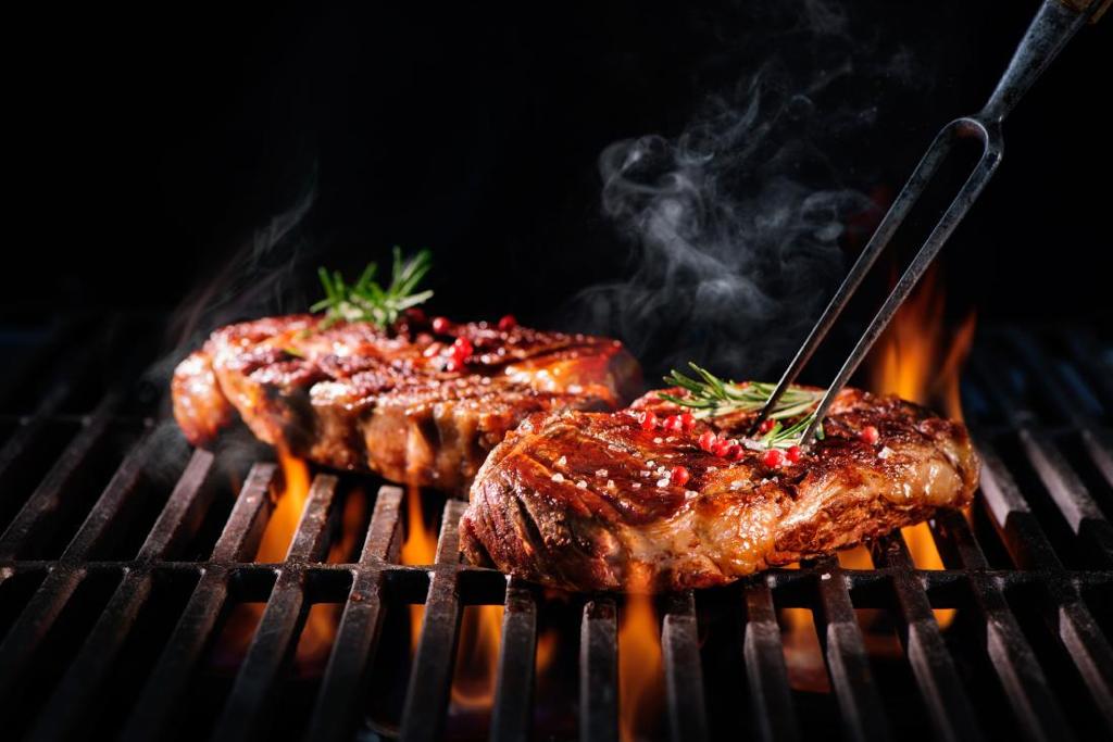Foto van vlees op een grill met vuur