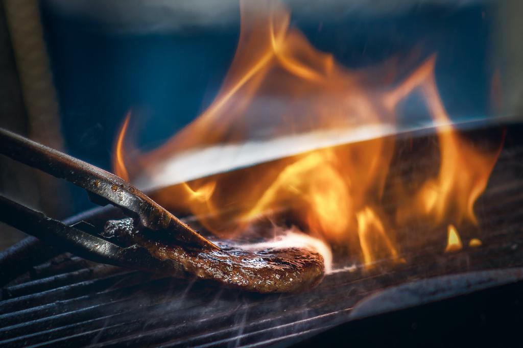 Foto van vlees op een grill met vuur