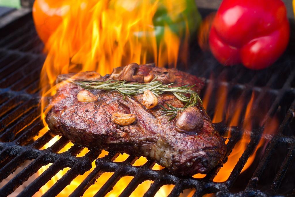 Foto van vlees op een grill met vuur